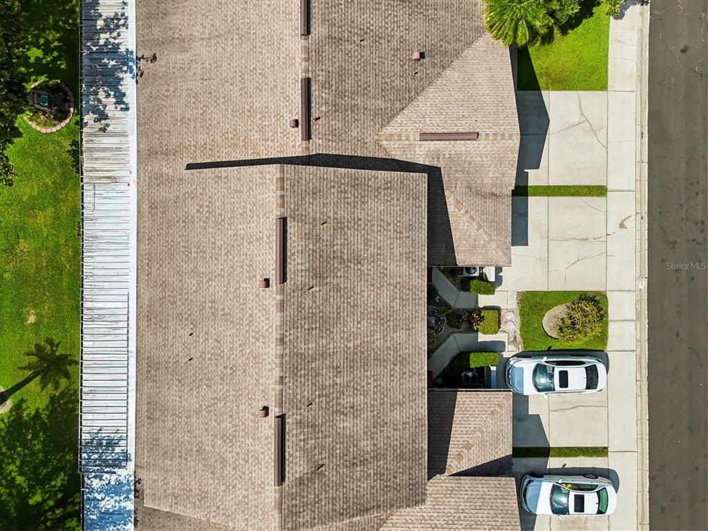 An aerial view shows the roof of a house with two parked cars nearby — 612 QUAIL KEEP DRIVE, SAFETY HARBOR, FL