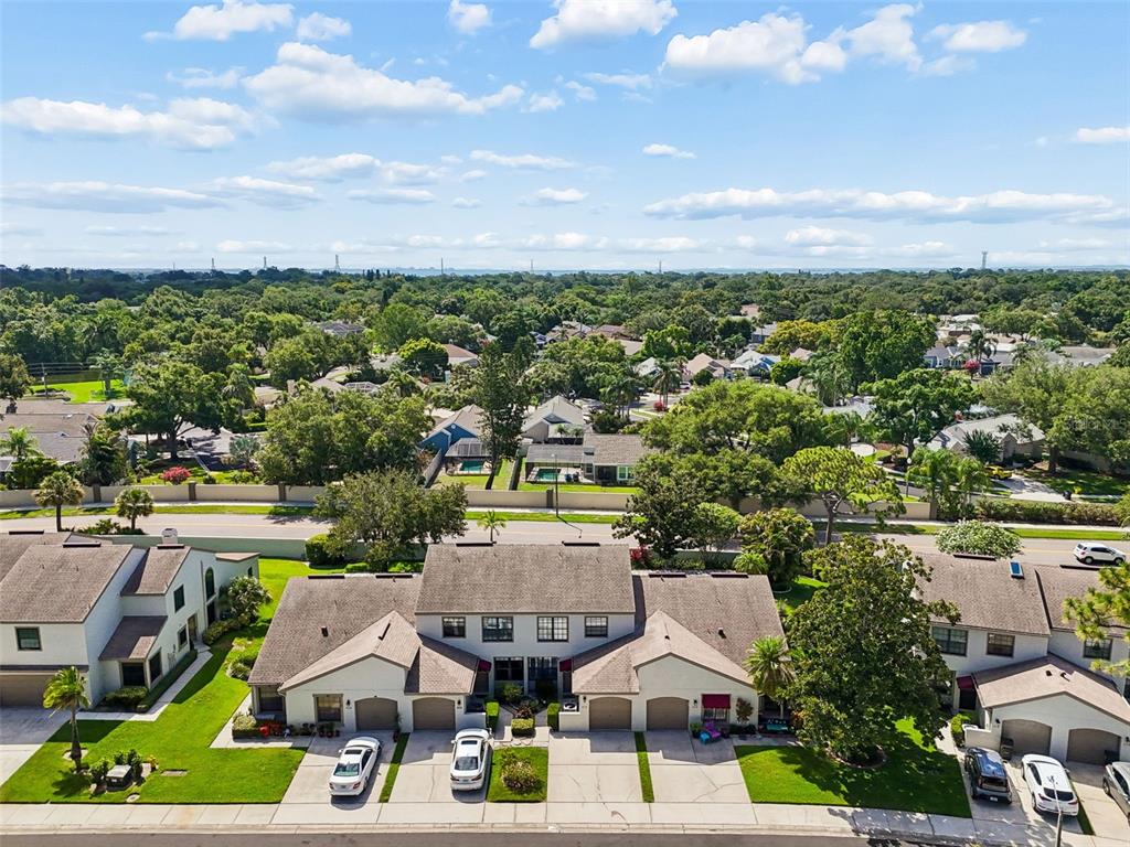 An aerial view shows a multi-unit townhouse complex with attached garages and surrounding residential landscaping — 612 QUAIL KEEP DRIVE, SAFETY HARBOR, FL