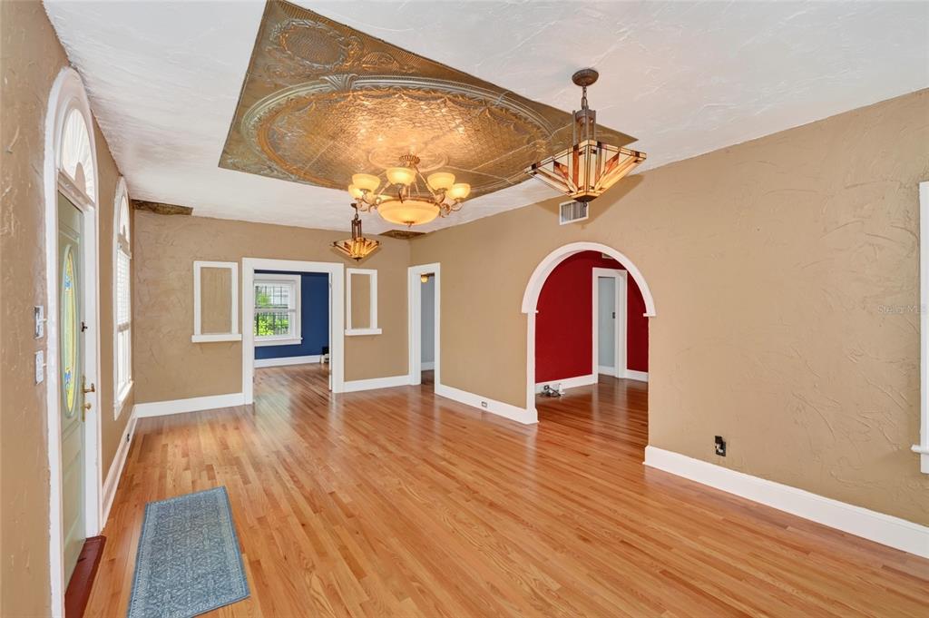 A living room with hardwood floors, a decorative ceiling medallion, and two arched doorways — 714 29TH STREET W, BRADENTON, FL
