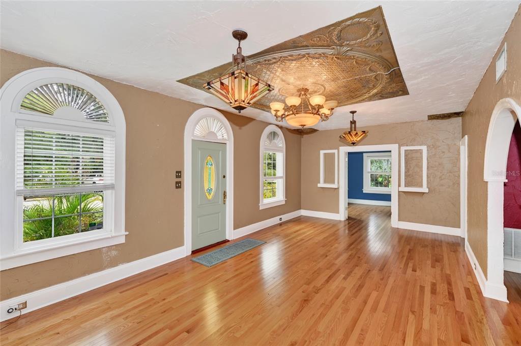 An entryway with hardwood floors, a decorative ceiling medallion, and arched windows and doorways — 714 29TH STREET W, BRADENTON, FL