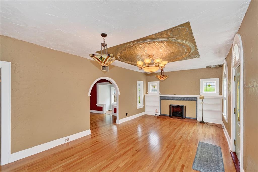 A living room features hardwood floors, a fireplace, and a decorative gold ceiling medallion — 714 29TH STREET W, BRADENTON, FL