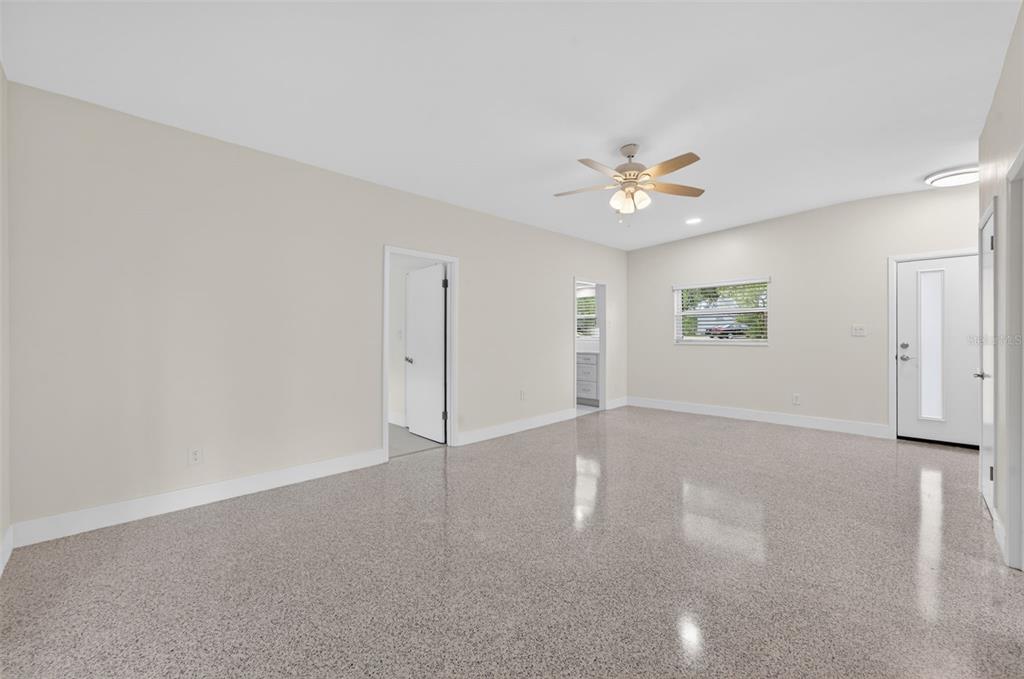 An empty room with light-colored walls, a ceiling fan, and speckled epoxy flooring — 2974 CHANTILLY AVENUE, WINTER PARK, FL