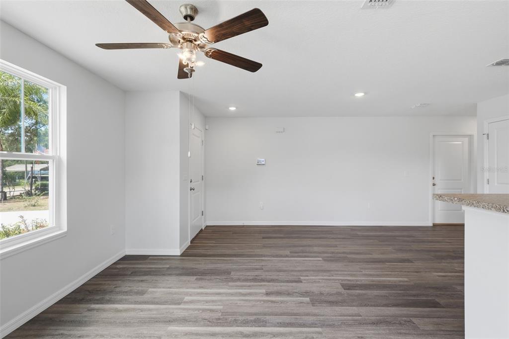 An empty room features wood-look flooring, white walls, a ceiling fan, and a window — 3411 WARREN SAPP DRIVE, APOPKA, FL