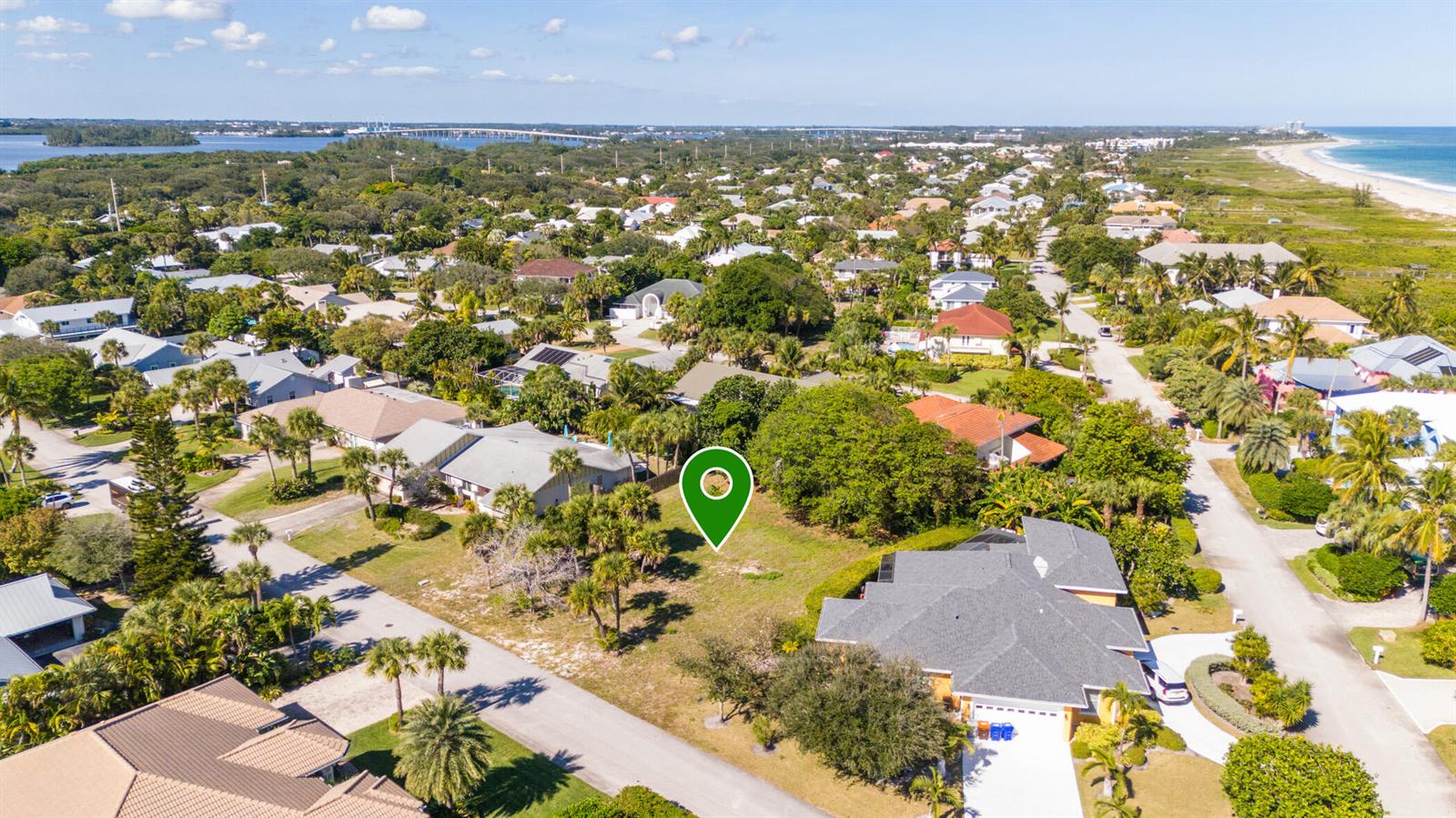 An aerial view shows a vacant residential lot surrounded by houses and tropical vegetation — 1370 White Heron Lane, Vero Beach FL 32963, VERO BEACH, FL
