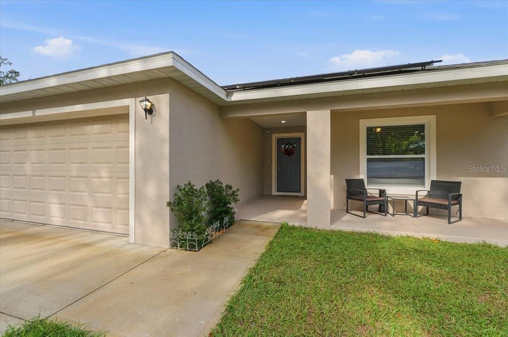The exterior of a single-story house features a garage, a covered entryway, and a lawn — 31 MORGAN STREET, AUBURNDALE, FL