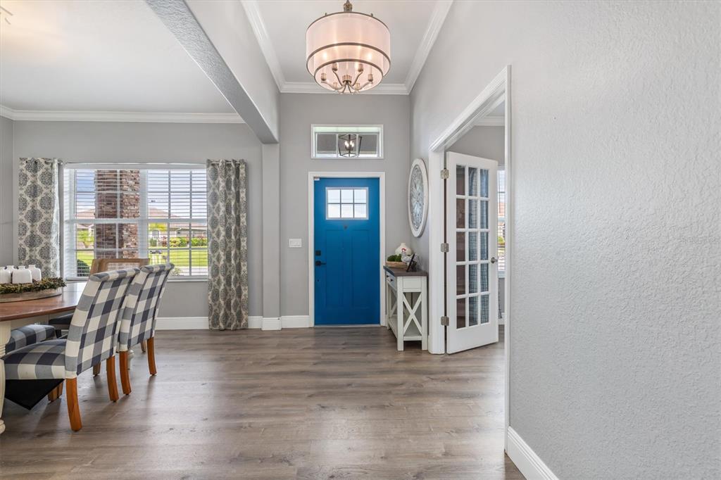 A dining area leads to a blue front door and a room with French doors — 9151 MELODY CIRCLE, PORT CHARLOTTE, FL