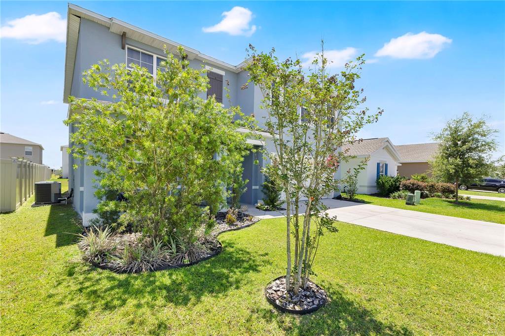 A two-story blue house features a front yard with a tree and a concrete driveway — 831 TURNER LANE, WINTER HAVEN, FL