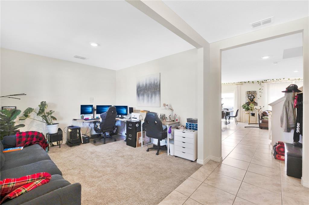 A carpeted home office area features two computer desks and a sofa near a tiled hallway — 831 TURNER LANE, WINTER HAVEN, FL