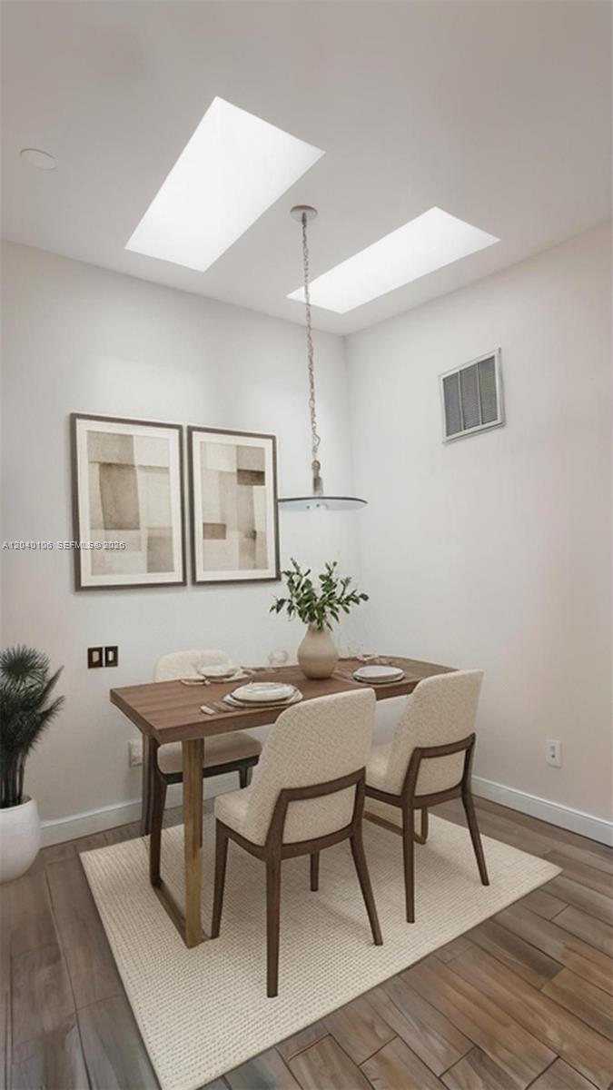 A dining area features a wooden table, four chairs, a rug, and two skylights — 2566 N Nob Hill Rd, Sunrise FL 33322, SUNRISE, FL