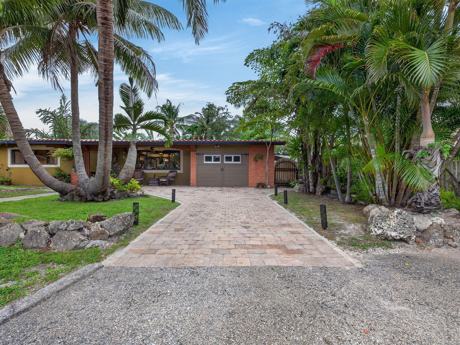 A single-story house with a brick facade, brown garage door, and a paved driveway — 949 NE 25th Avenue, Pompano Beach FL 33062, POMPANO BEACH, FL