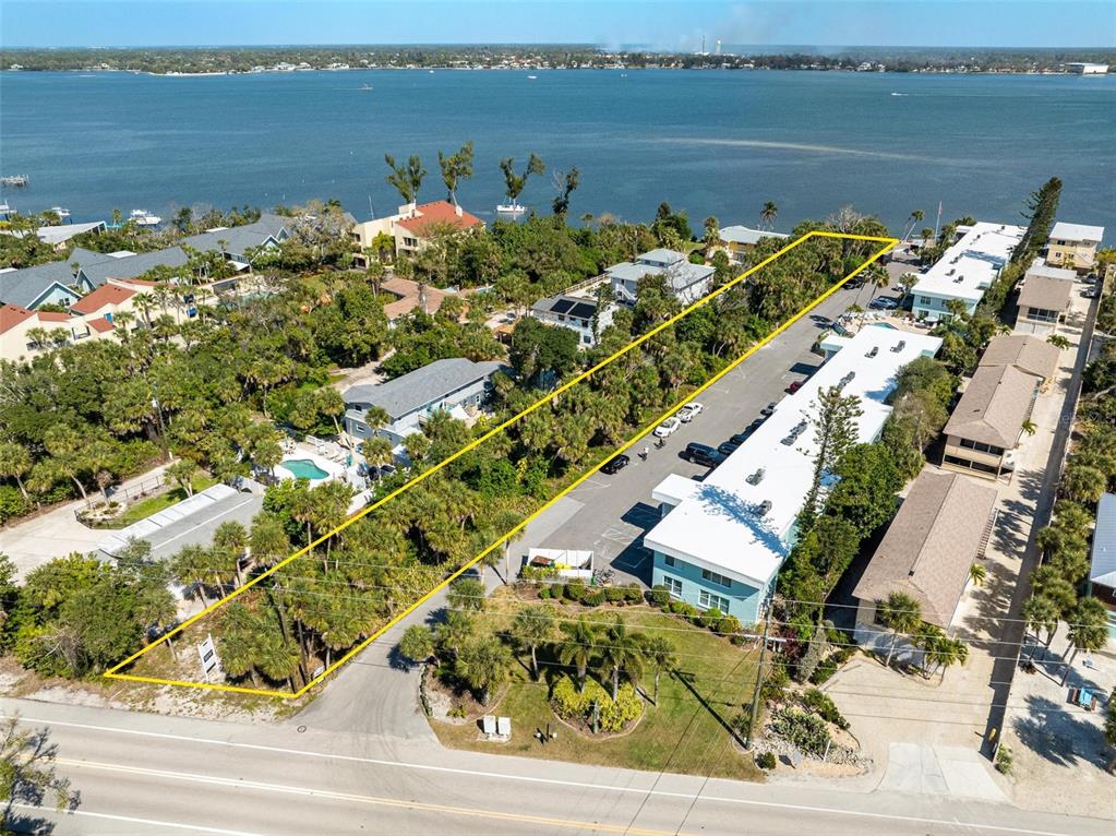 An aerial view shows a rectangular property lot outlined in yellow near a waterfront — 5065 N BEACH ROAD, ENGLEWOOD, FL