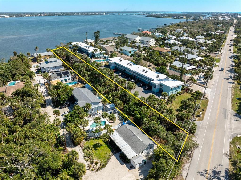 An aerial view shows a rectangular lot with trees and a house near a road — 5065 N BEACH ROAD, ENGLEWOOD, FL