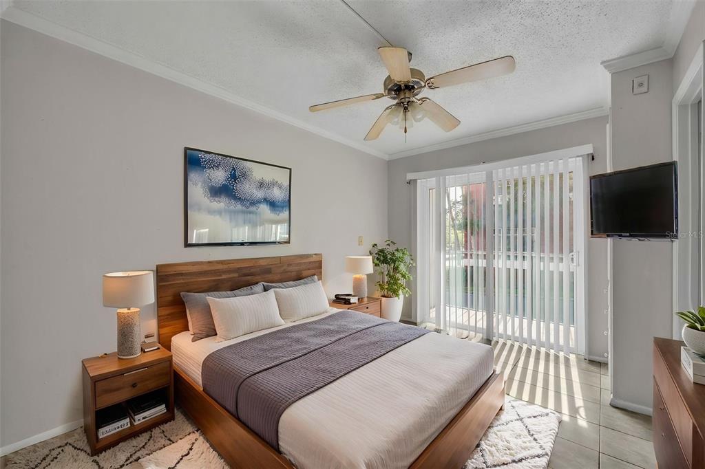 A bedroom features a wooden bed frame, two nightstands, a ceiling fan, and sliding glass doors — 145 OYSTER BAY CIRCLE UNIT 240, ALTAMONTE SPRINGS, FL