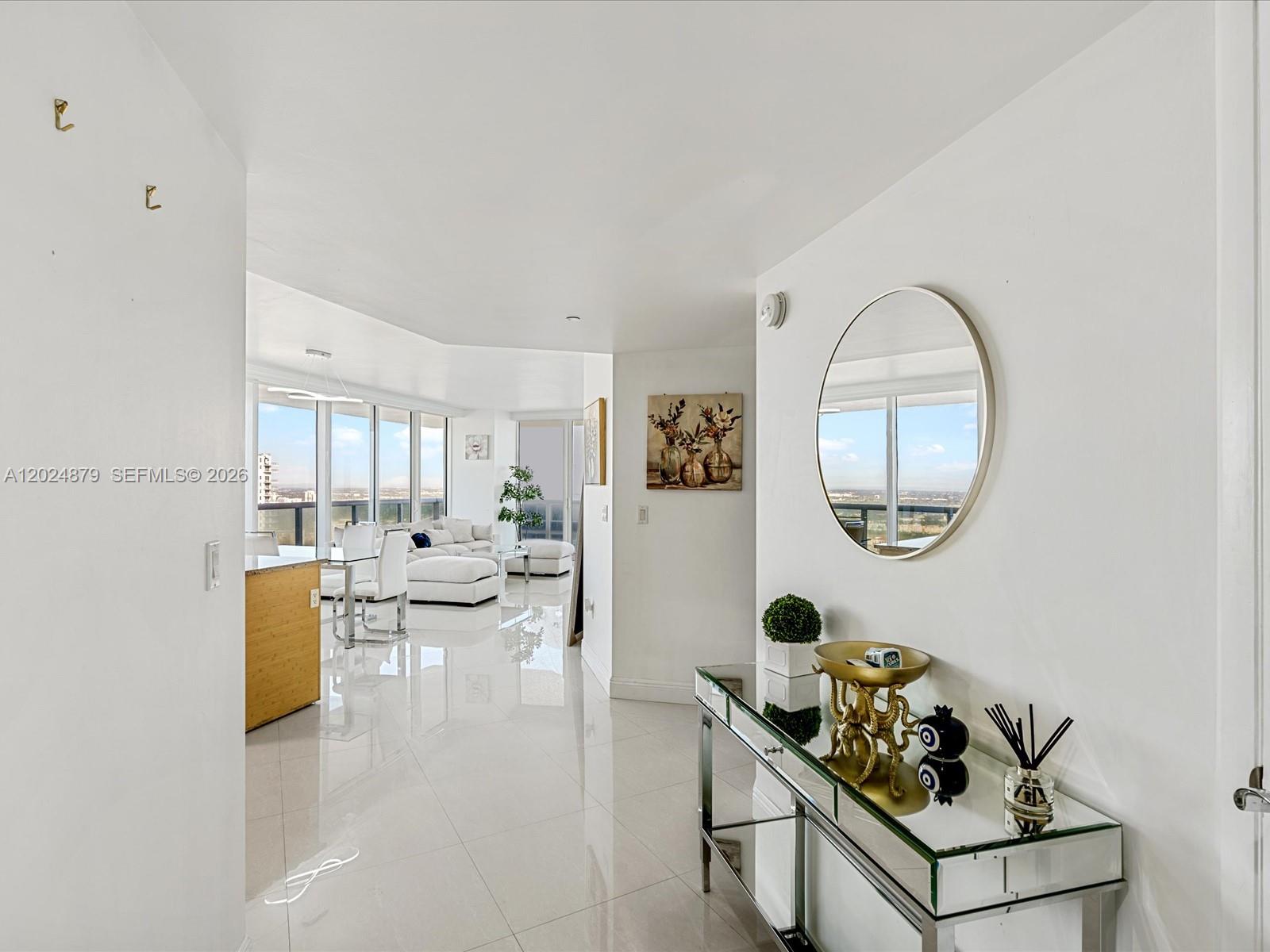 A bright entryway with a mirrored console table leads into an open-concept living area — 1830 S Ocean Dr # 4508, Hallandale Beach FL 33009, HALLANDALE BEACH, FL