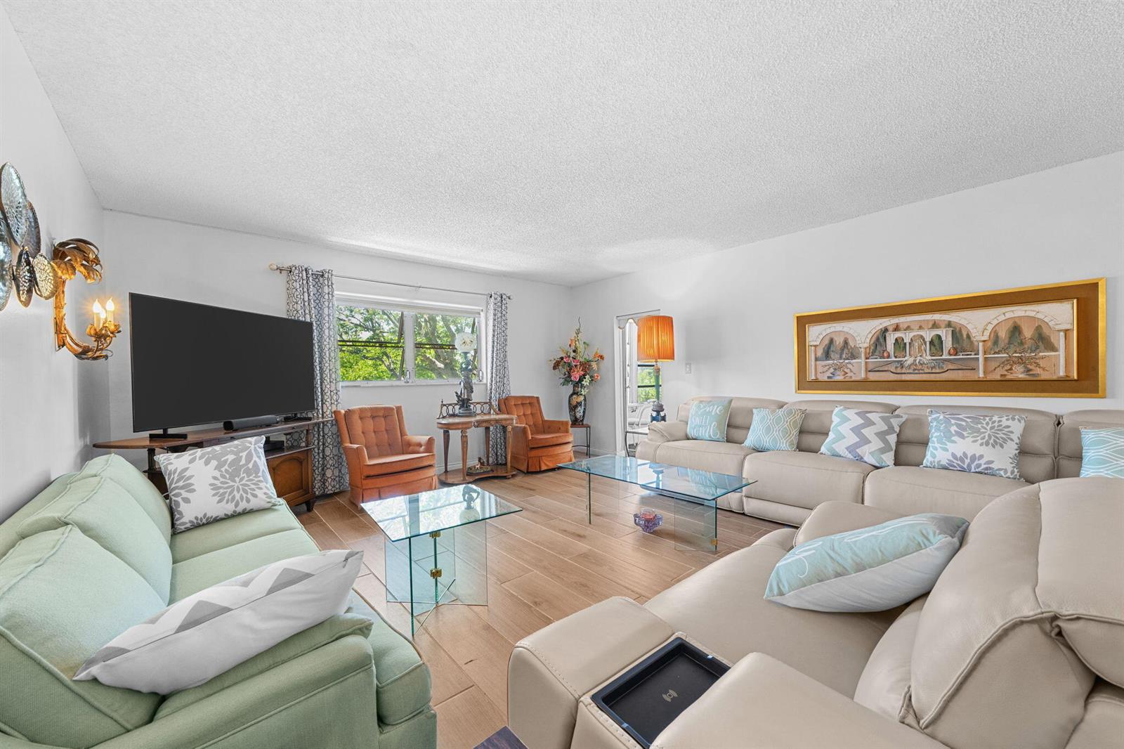 A living room features light wood-look tile flooring, a large sectional sofa, and two armchairs — 2271 NW 48th Terrace # 207, Lauderhill FL 33313, LAUDERHILL, FL