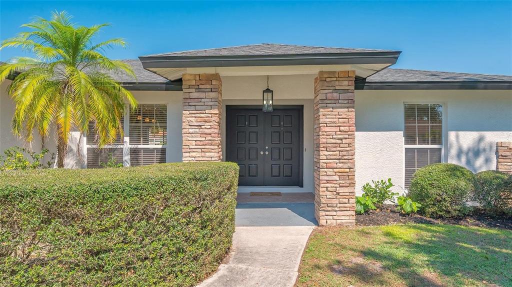 A front exterior view of a house featuring a stone-columned entryway and double doors — 3033 GRAFTON STREET, SARASOTA, FL