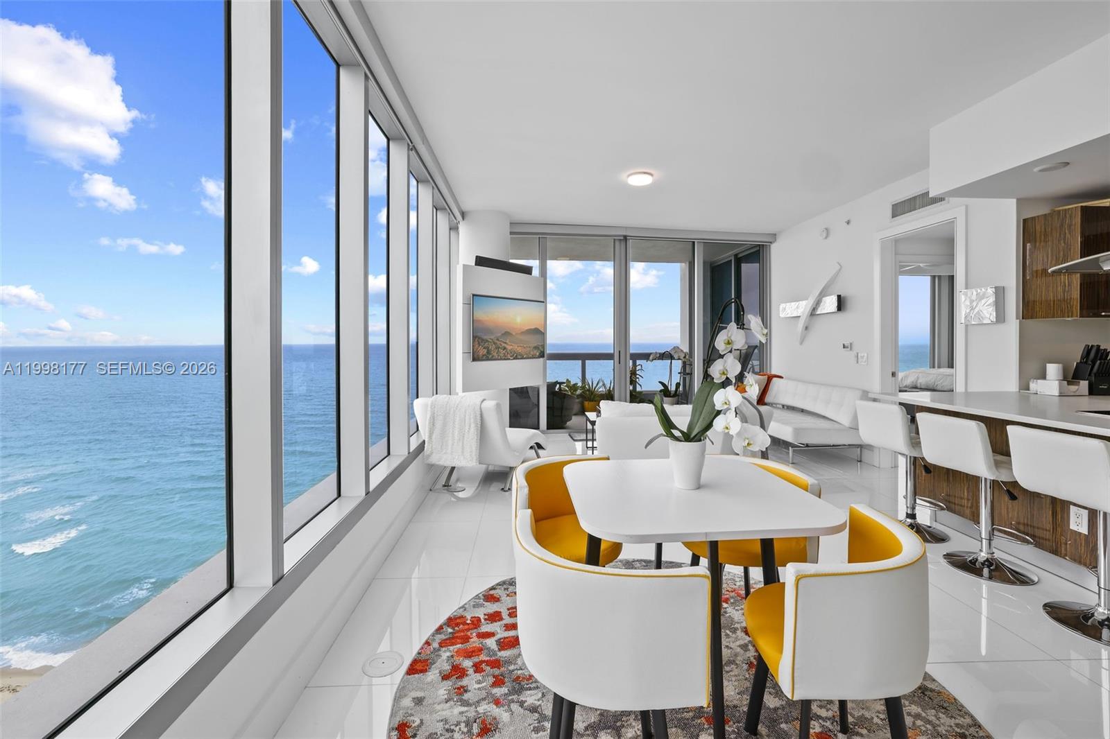 A bright, modern dining and living area features floor-to-ceiling windows overlooking the ocean — 6899 Collins Ave # 1905, Miami Beach FL 33141, MIAMI BEACH, FL