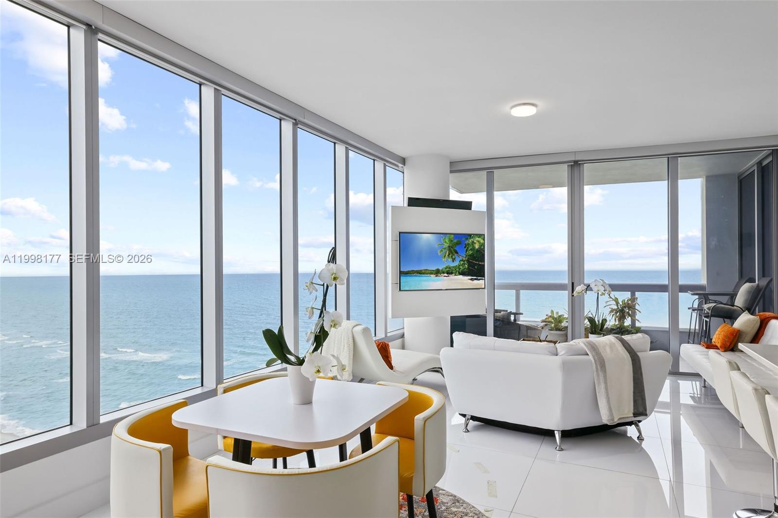 A bright living and dining area features floor-to-ceiling windows with expansive ocean views — 6899 Collins Ave # 1905, Miami Beach FL 33141, MIAMI BEACH, FL