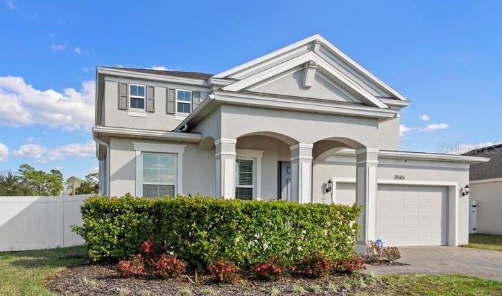 A two-story suburban house with a light gray exterior, a front porch, and a garage — 3565 FERNANDA DRIVE, DELTONA, FL
