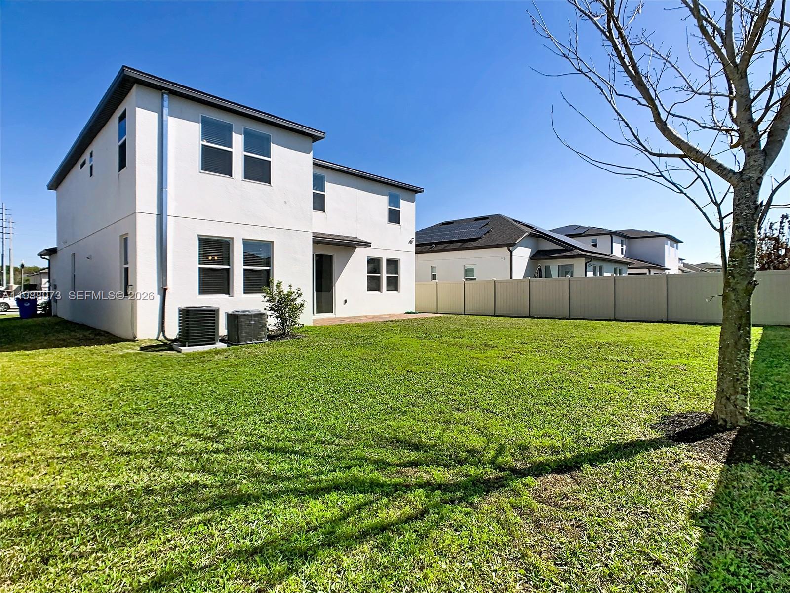 The exterior view shows the back of a two-story house with a fenced backyard — 1285 Hilltop Place, Saint Cloud FL 34772, SAINT CLOUD, FL