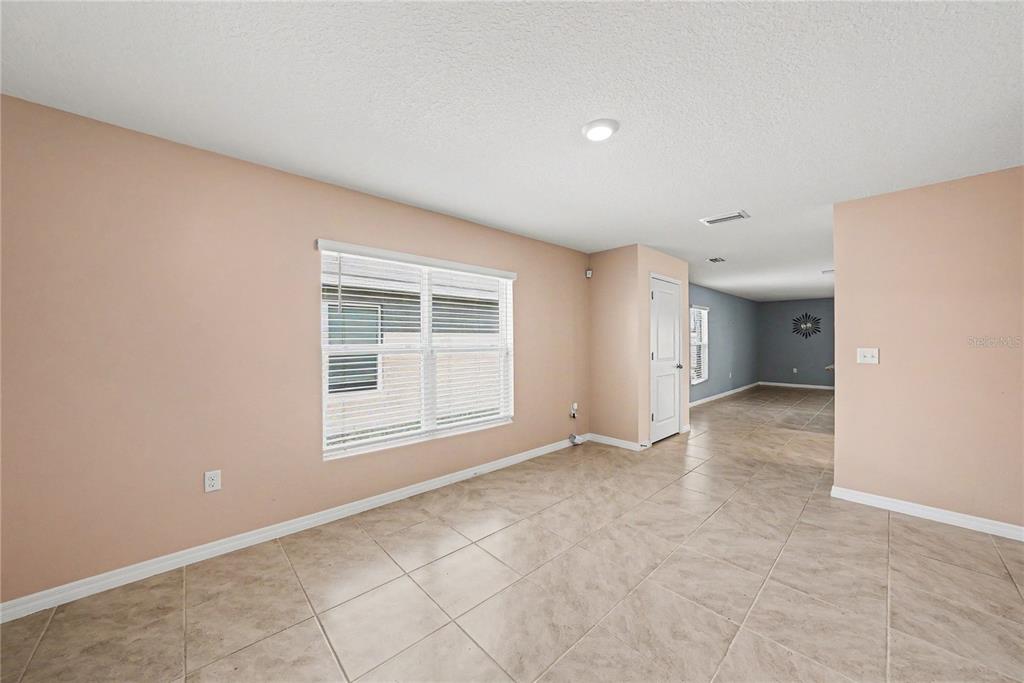 An empty room with beige walls, tile flooring, and a window with white blinds — 11453 STONE PINE STREET, RIVERVIEW, FL