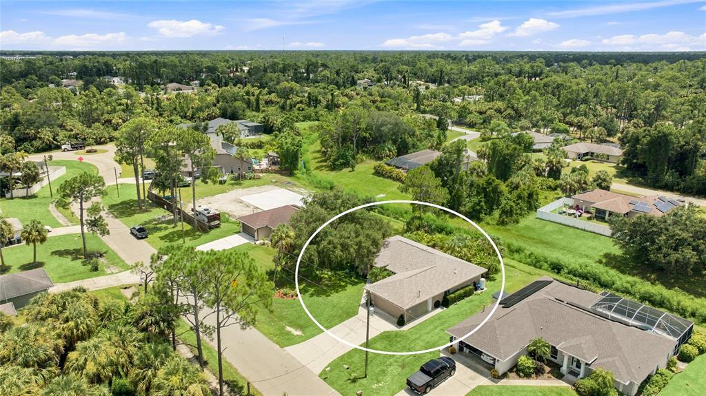An aerial view shows a single-story house with a tan roof and a concrete driveway — 2451 ALTOONA AVENUE, NORTH PORT, FL