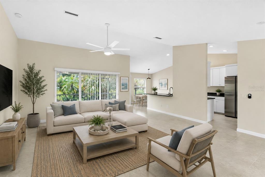 A living room with a sectional sofa, coffee table, and an open kitchen in the background — 2451 ALTOONA AVENUE, NORTH PORT, FL