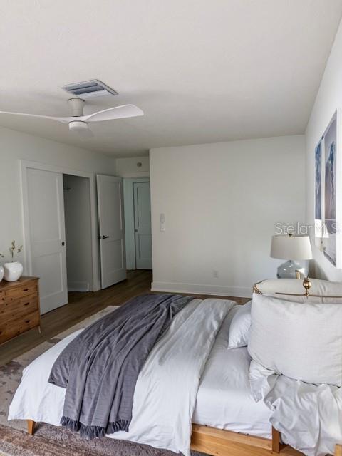 A bedroom features a bed with white bedding, a grey throw, and a ceiling fan — 582 BOCA CIEGA POINT BOULEVARD N, ST PETERSBURG, FL