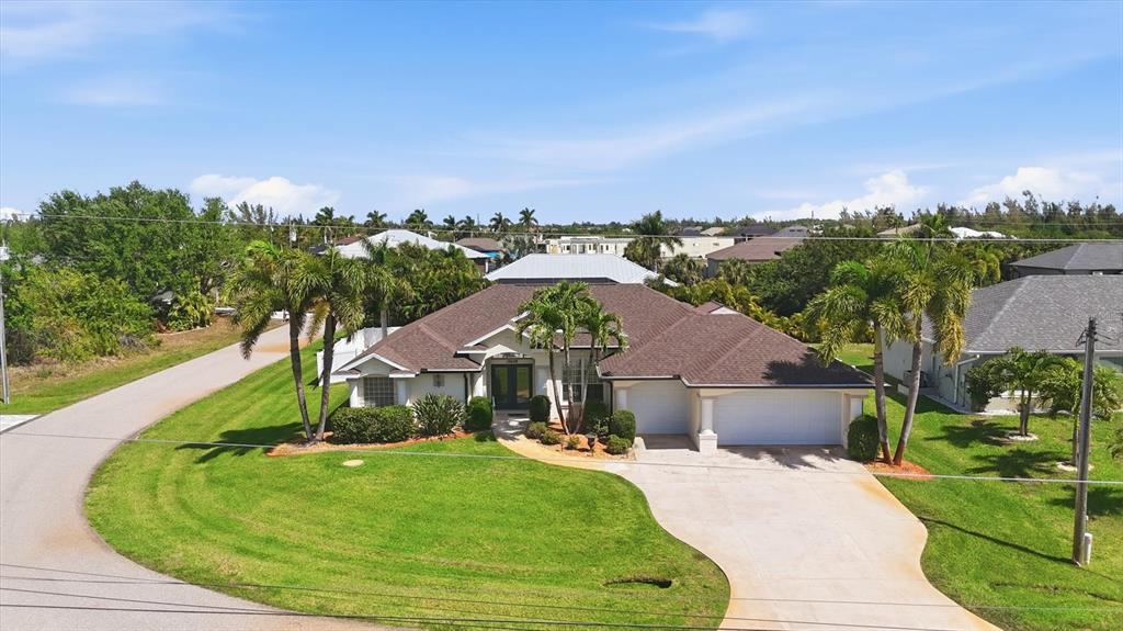An aerial view of a single-story suburban house with a brown roof and palm trees — 15629 HAVANA CIRCLE, PORT CHARLOTTE, FL