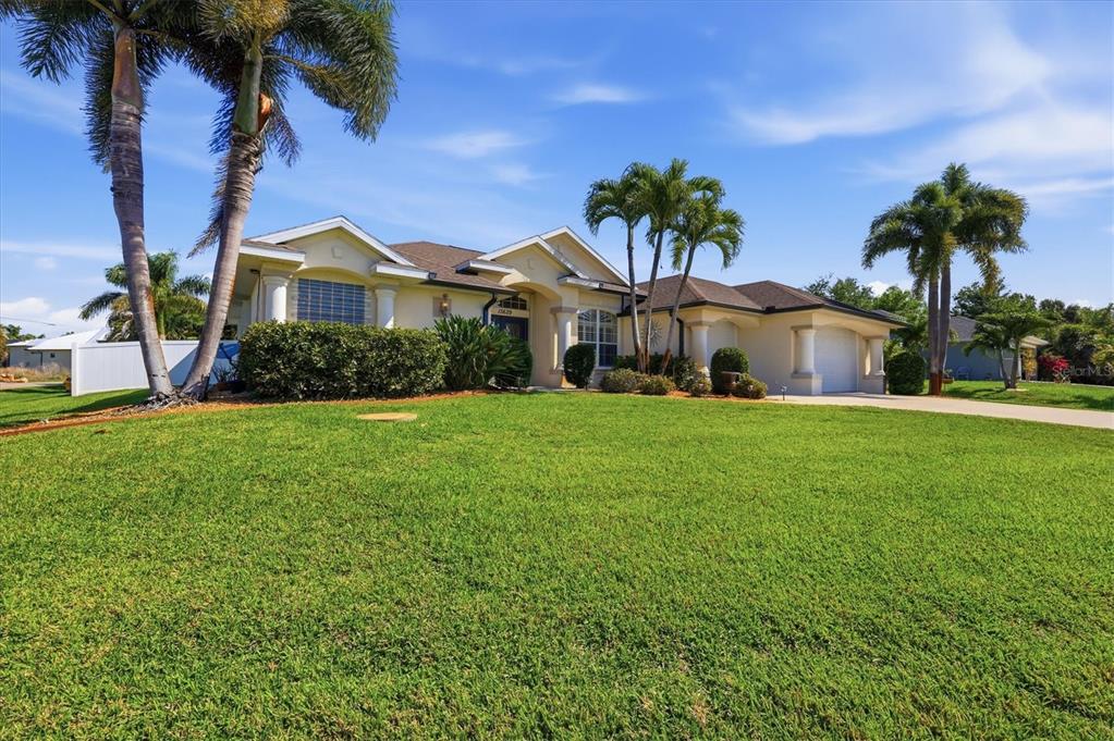 A single-story house with a large lawn, palm trees, and an attached garage — 15629 HAVANA CIRCLE, PORT CHARLOTTE, FL