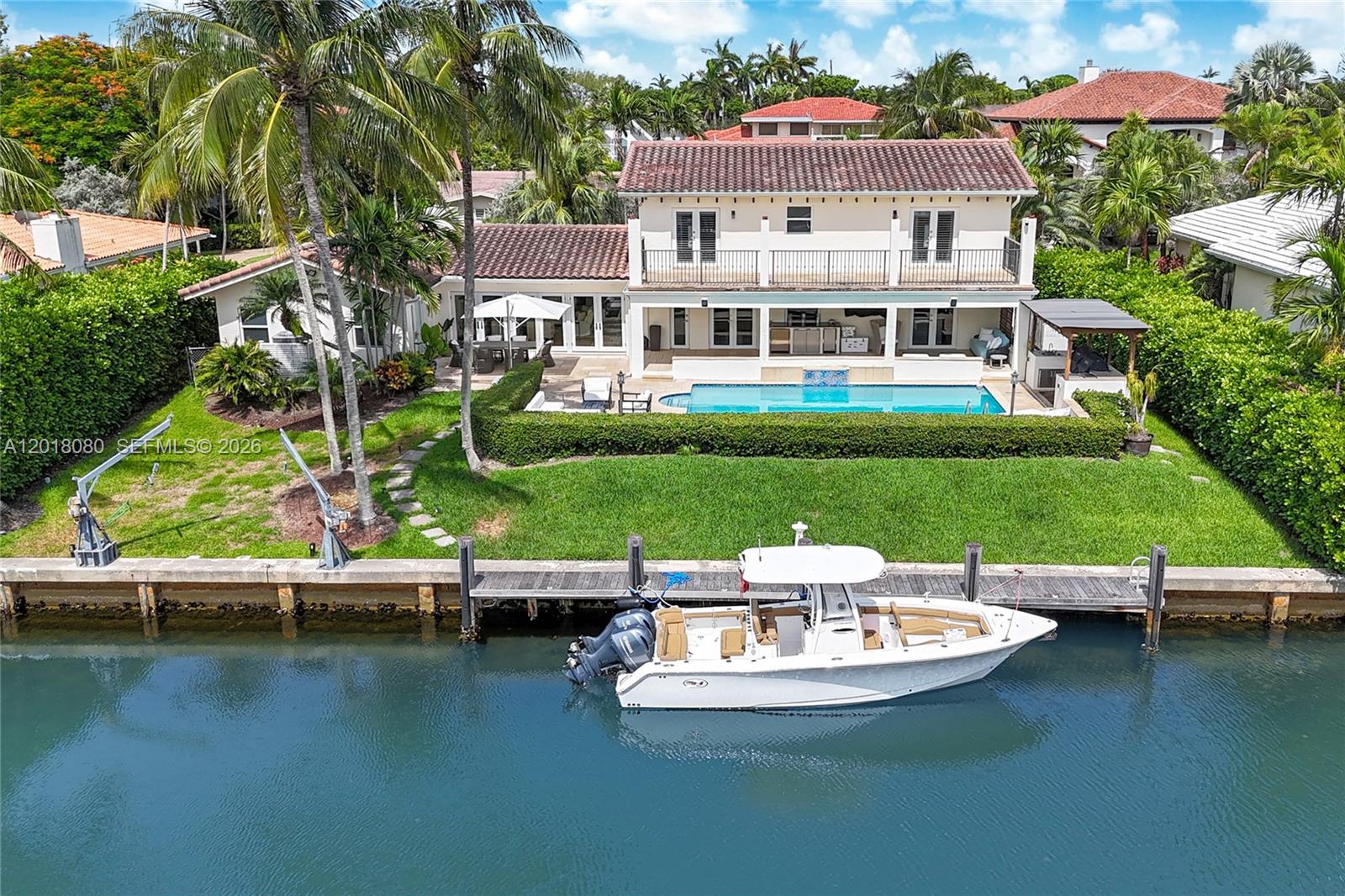A two-story house with a pool, patio, and boat docked on a canal — 13035 Nevada St, Coral Gables FL 33156, CORAL GABLES, FL