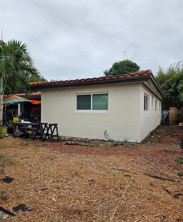 The exterior of a beige stucco house features a red tile roof and sliding windows — 490 NW 29TH AVENUE, FORT LAUDERDALE, FL