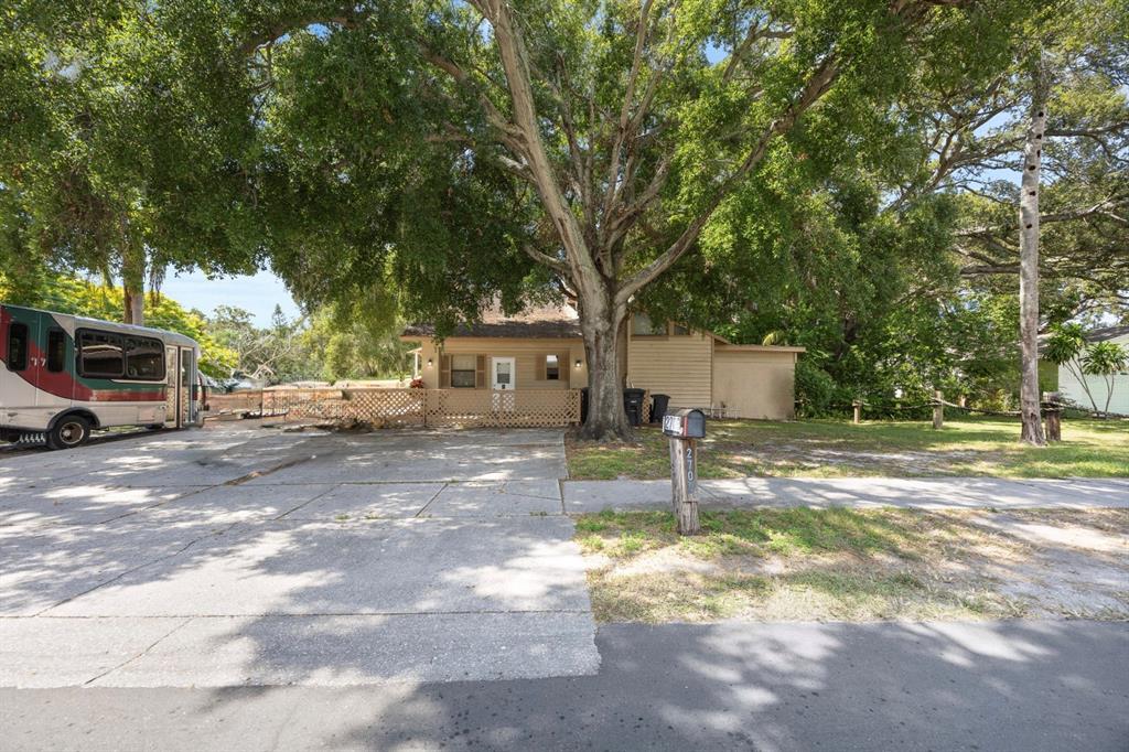 A single-story house with a large tree in the front yard and a parked RV — 2700 STATE ROAD 590, CLEARWATER, FL