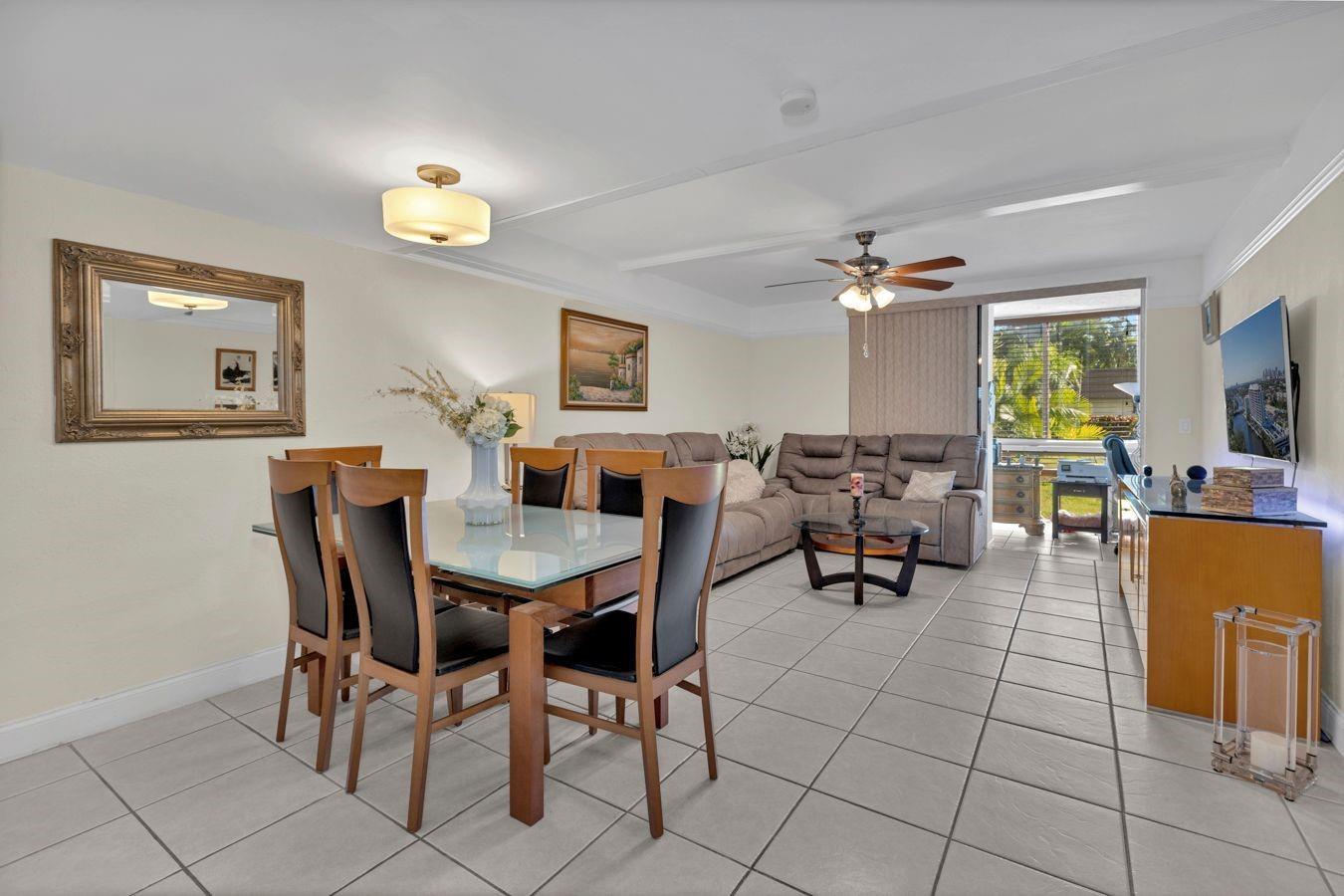 A dining area and living room with tile floors, a glass table, and sliding doors — 6850 Royal Palm Boulevard # 106, Margate FL 33063, MARGATE, FL