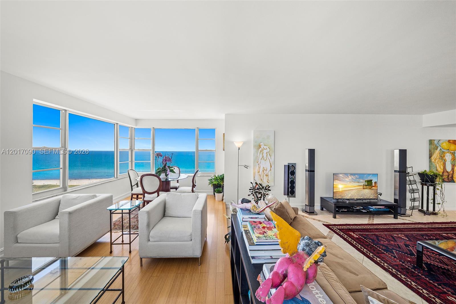 A living room with light wood floors, ocean views, and a large red area rug — 5255 Collins Ave # 9F, Miami Beach FL 33140, MIAMI BEACH, FL