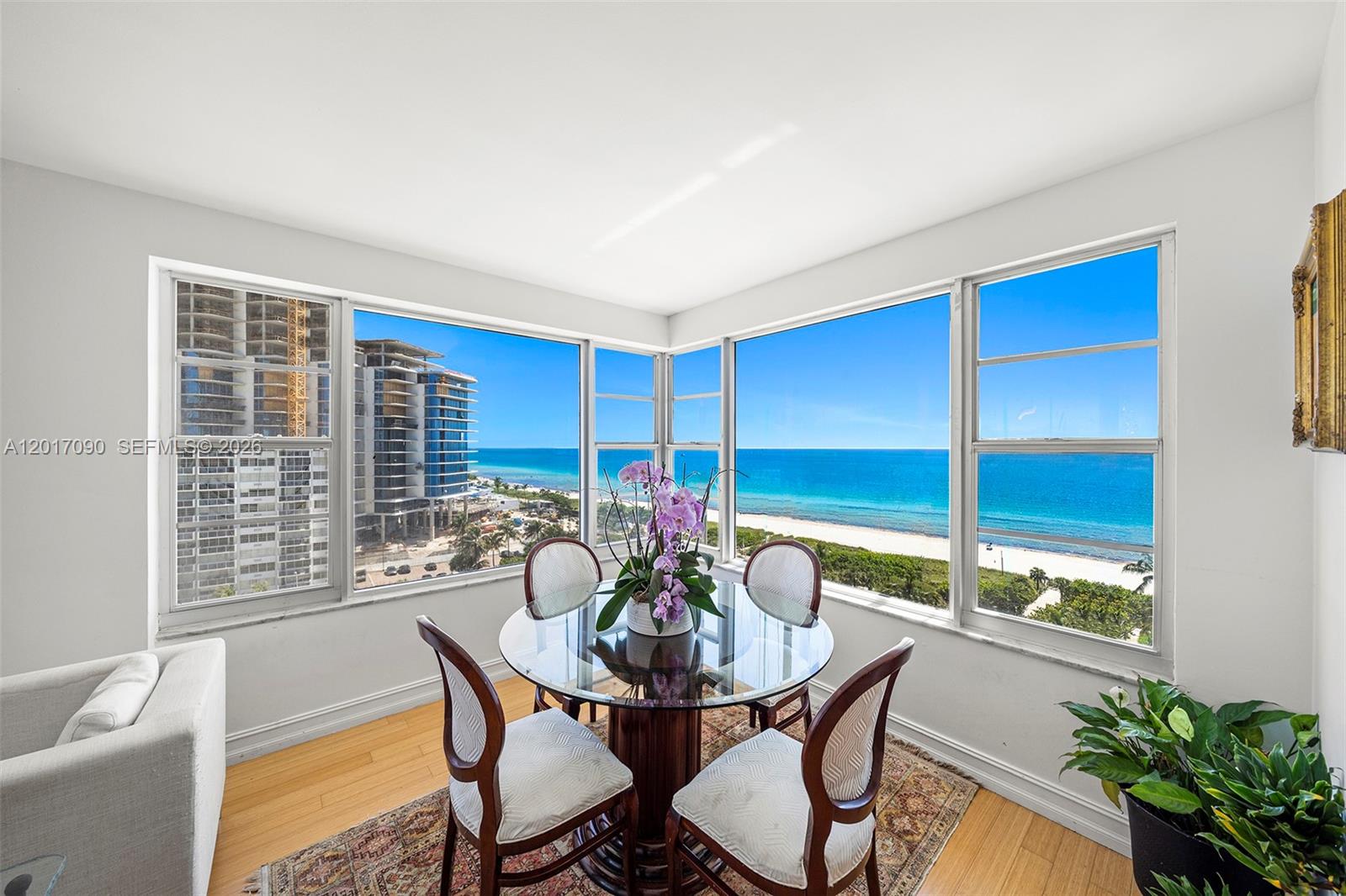 A dining area with a glass table and ocean views through large corner windows — 5255 Collins Ave # 9F, Miami Beach FL 33140, MIAMI BEACH, FL