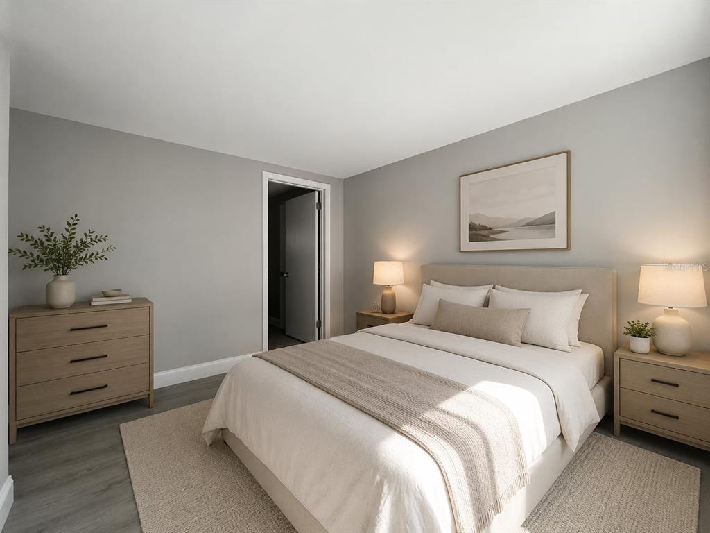 A bedroom features a bed with neutral bedding, two nightstands, a dresser, and gray walls — 2704 E COLUMBUS DRIVE UNIT A, TAMPA, FL