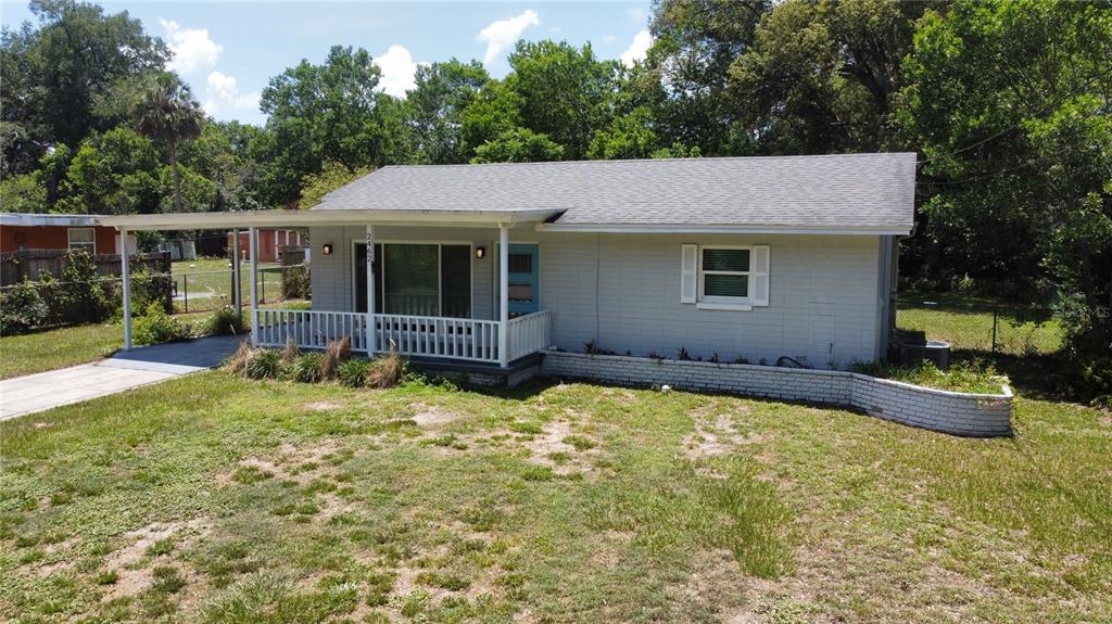 A single-story house with a gray exterior, a front porch, and a low brick planter — 2462 HARVARD ROAD, DELAND, FL