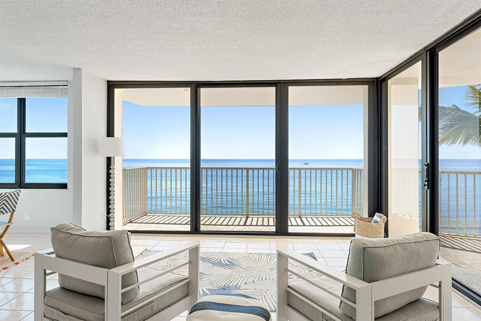 A living area features two armchairs facing a balcony with expansive ocean views — 5480 N Ocean Drive, Singer Island FL 33404, SINGER ISLAND, FL