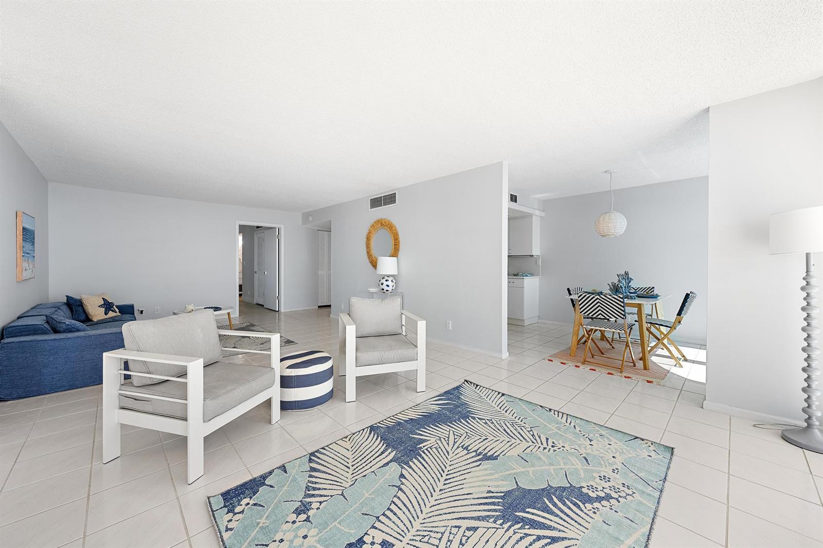 A living and dining area features white tile floors, light gray walls, and coastal decor — 5480 N Ocean Drive, Singer Island FL 33404, SINGER ISLAND, FL