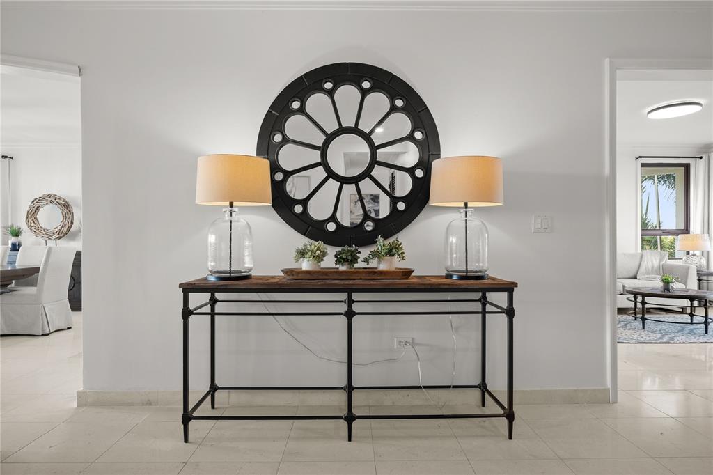 A console table with two lamps and a round mirror sits in a white hallway — 400 COCO BEACH BVL UNIT 302B, RIO GRANDE, PR