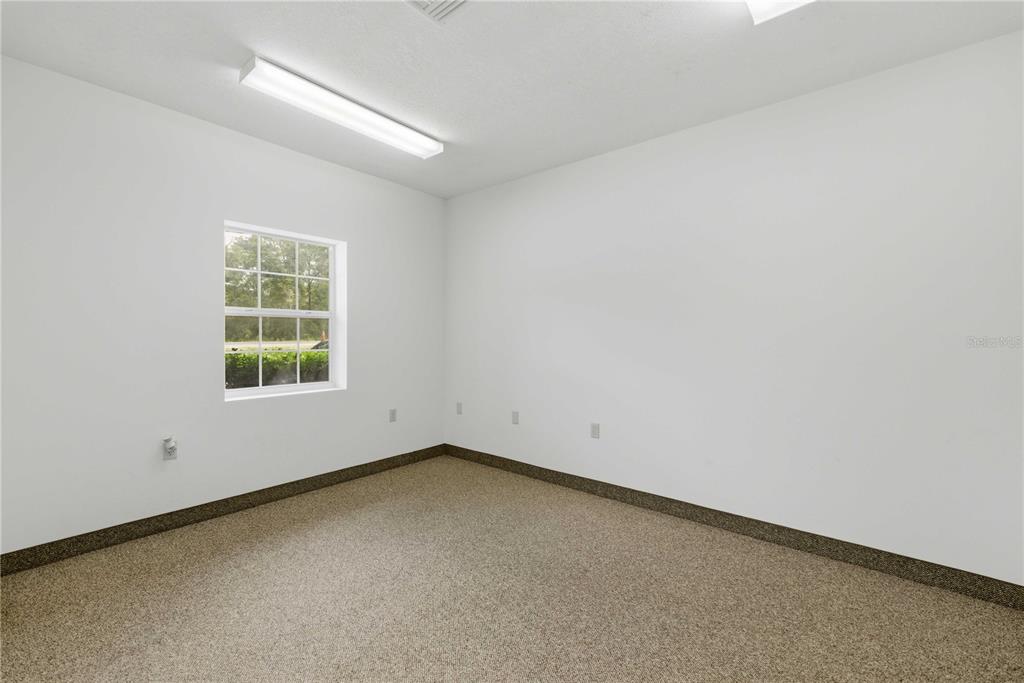 An empty room with white walls, beige carpet, a single window, and a fluorescent light — 4370 NE 35TH STREET UNIT 3, OCALA, FL