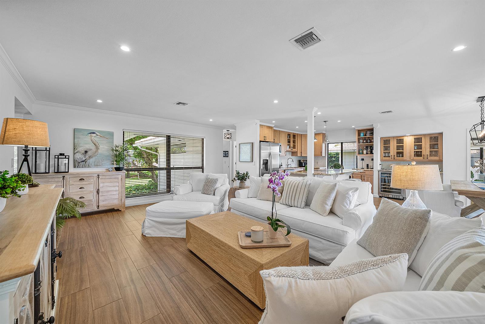 A bright, open-concept living room features white furniture, a woven coffee table, and wood-look flooring — 3660 N Quail Ridge Dr Drive, Boynton Beach FL 33436, BOYNTON BEACH, FL