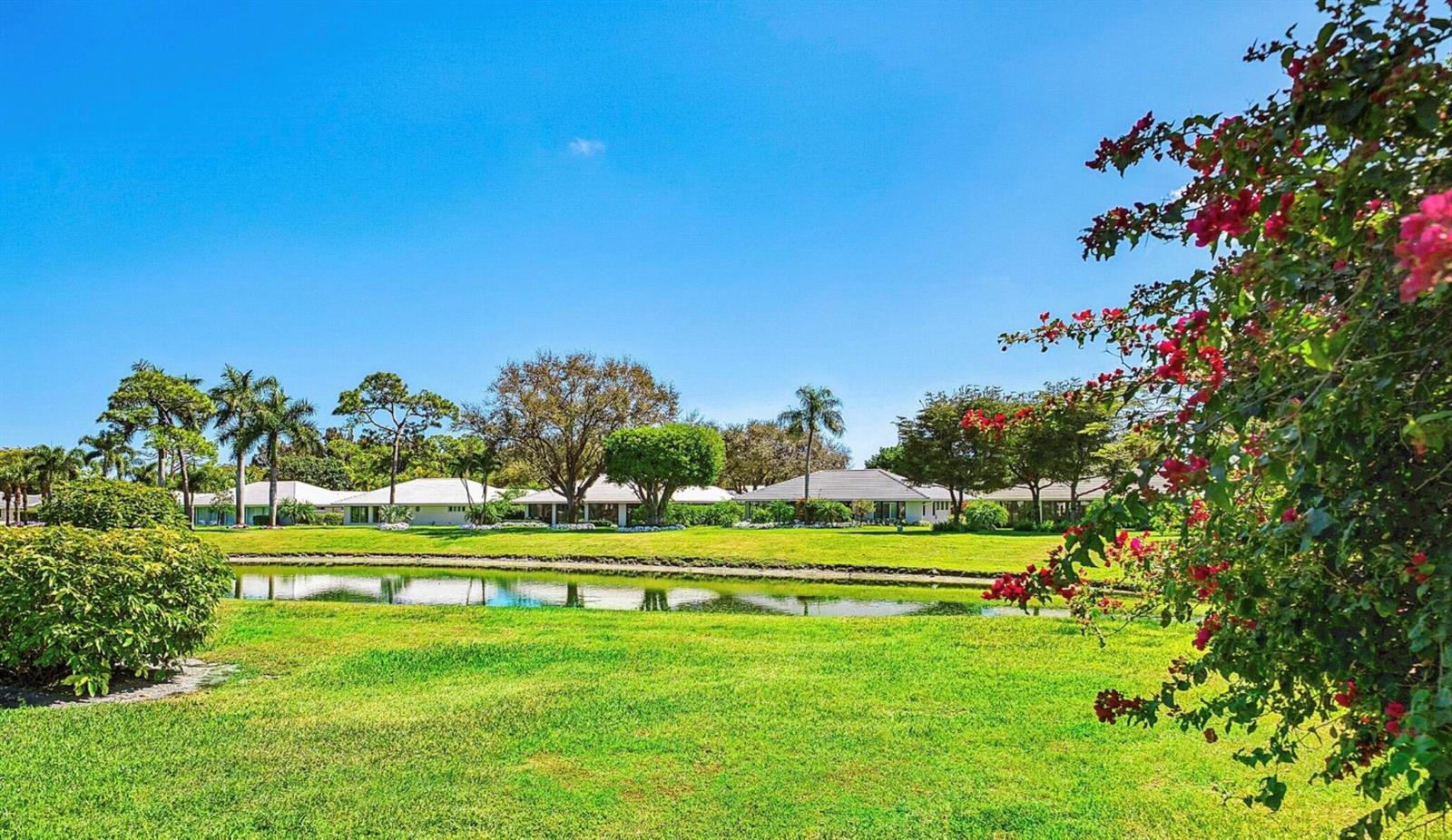 A grassy lawn and pond in front of a row of single-story residential buildings — 3660 N Quail Ridge Dr Drive, Boynton Beach FL 33436, BOYNTON BEACH, FL