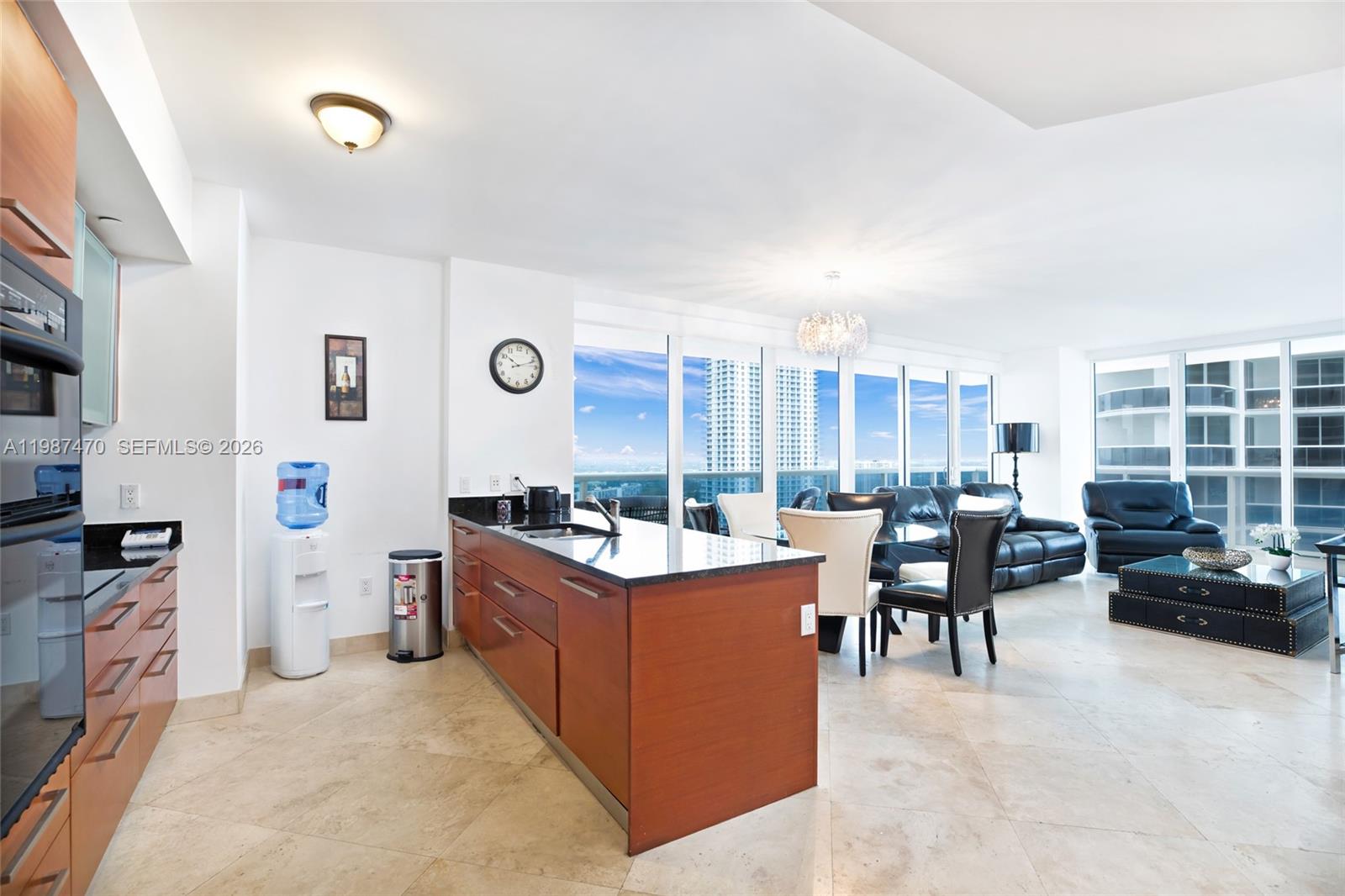 A modern open-concept kitchen and living area features wood cabinetry, granite countertops, and floor-to-ceiling windows — 1830 S Ocean Dr # 2808, Hallandale Beach FL 33009, HALLANDALE BEACH, FL