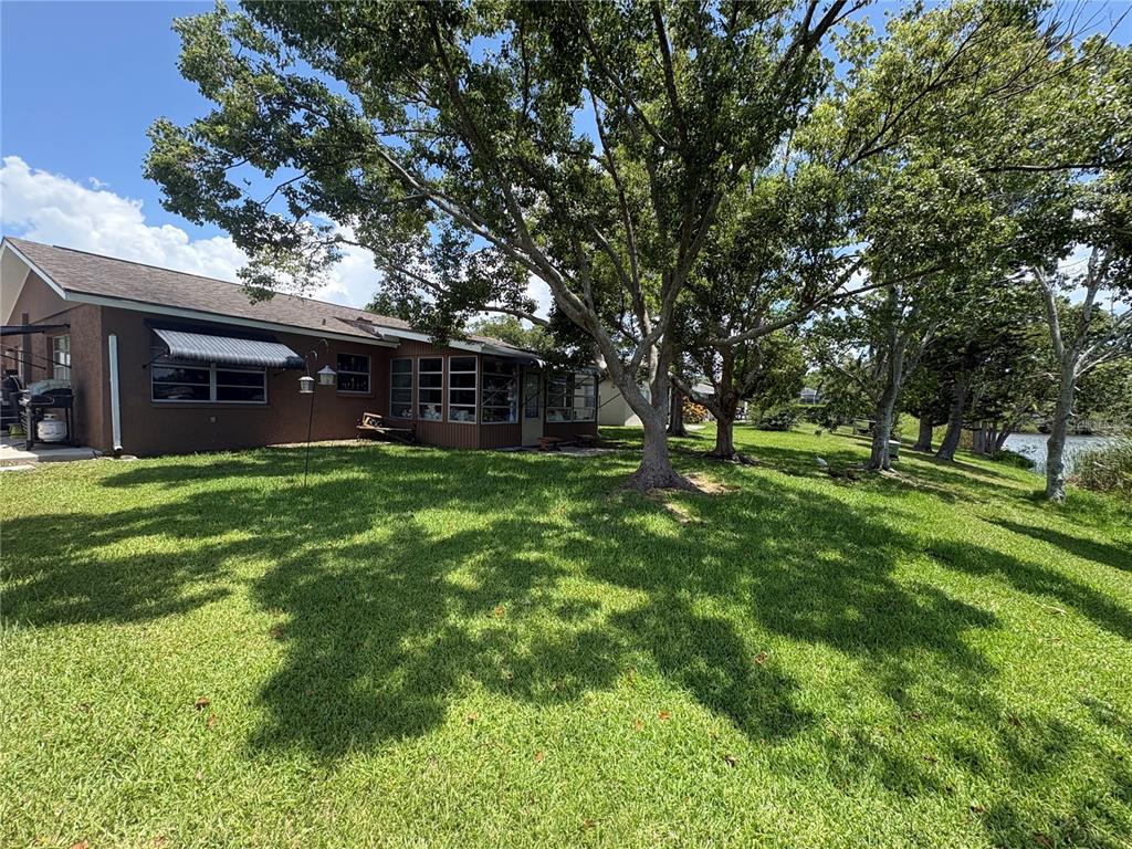 A single-story house with a two-car garage, concrete driveway, and a palm tree in front — 5049 SHERRY LANE, NEW PORT RICHEY, FL