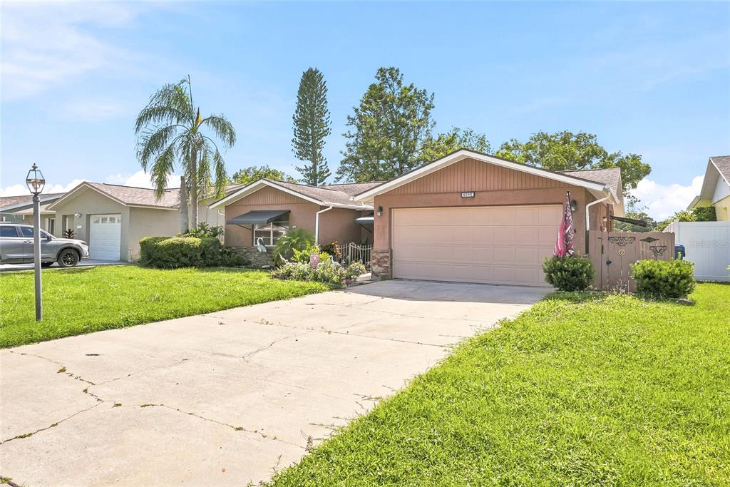 A dining area with a wooden table and chairs opens into a living room — 5049 SHERRY LANE, NEW PORT RICHEY, FL