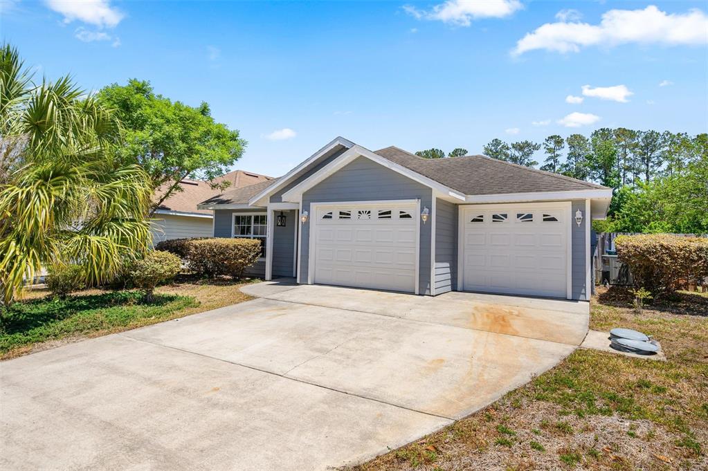 A single-story house with gray siding, a two-car garage, and a concrete driveway — 11753 NW 60TH TERRACE, ALACHUA, FL