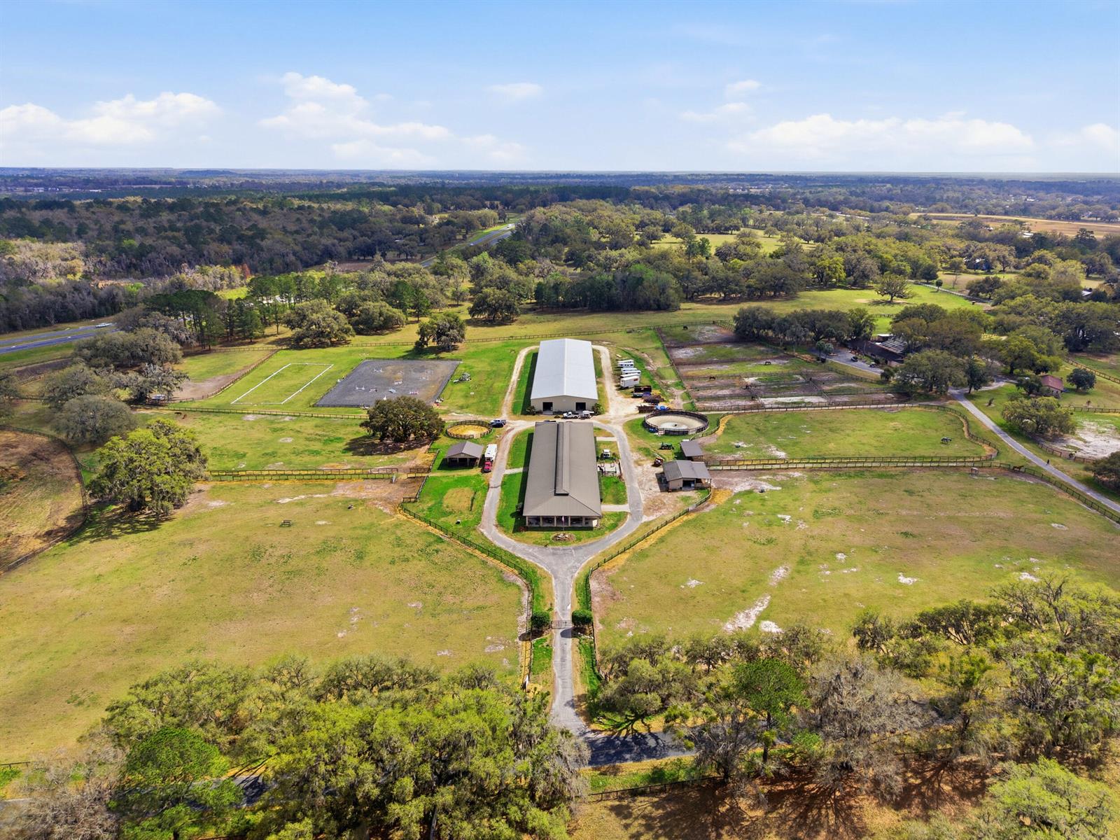 An aerial view shows a horse farm with two large barns, paddocks, and riding arenas — 6025 NW 115th Avenue, Ocala FL 34482, OCALA, FL