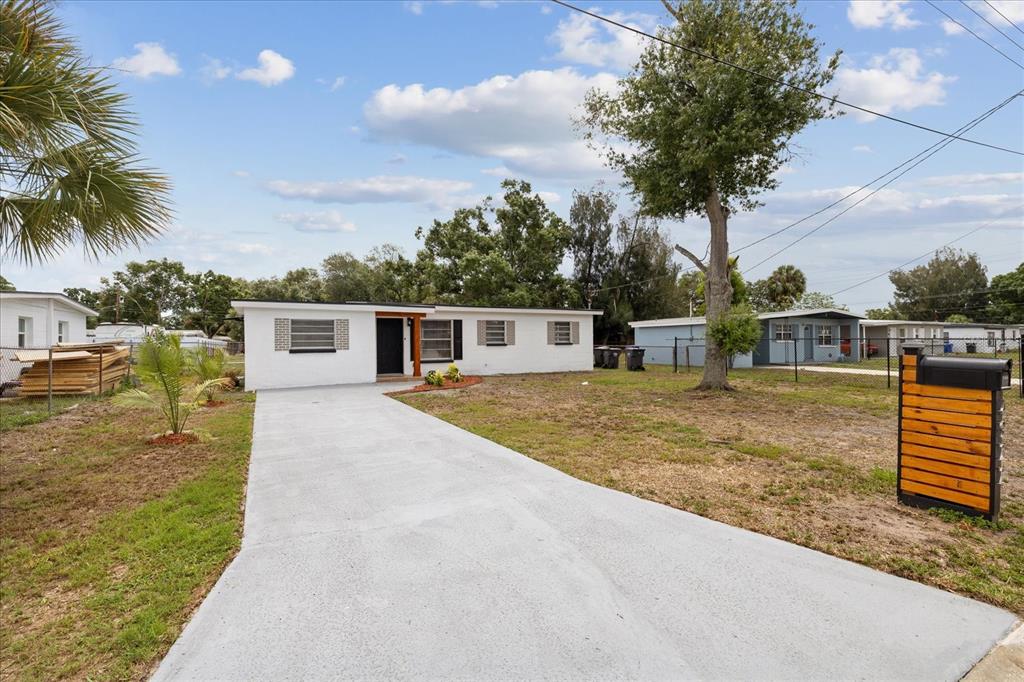 A white single-story house with a concrete driveway and a wooden mailbox post — 4922 S 82ND STREET, TAMPA, FL